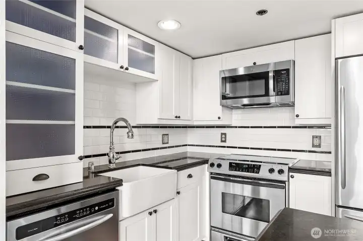 Designed with style in mind, the kitchen showcases stainless appliances and decorative glass-front cabinetry.