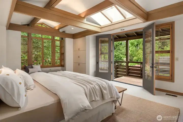 Wake up to verdant views on all sides in this lovely primary, with exposed Douglas Fir structural members, skylights, French doors, and just a few steps to your built-in spa Wake up to verdant views on all sides in this lovely primary, with exposed Douglas Fir structural members, skylights, French doors, and just a few steps to your built-in spa