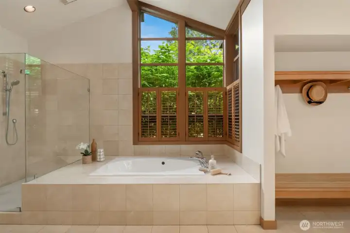 Vaulted ceilings in primary bath with lovely wood windows, double vanity, custom cabinetry and frameless shower enclosure Vaulted ceilings in primary bath with lovely wood windows, double vanity, custom cabinetry and frameless shower enclosure