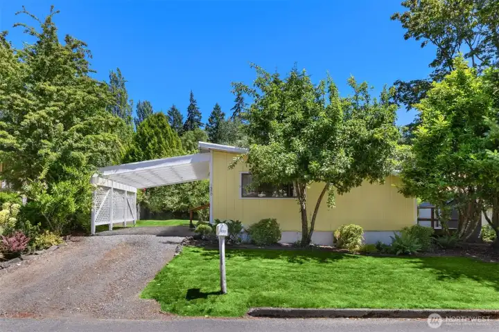 The property offers covered parking under the carport, plus an additional parking space between the carport and the road.