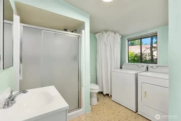 The bathroom conveniently houses the laundry area and water heater, maximizing the home's efficient use of space.