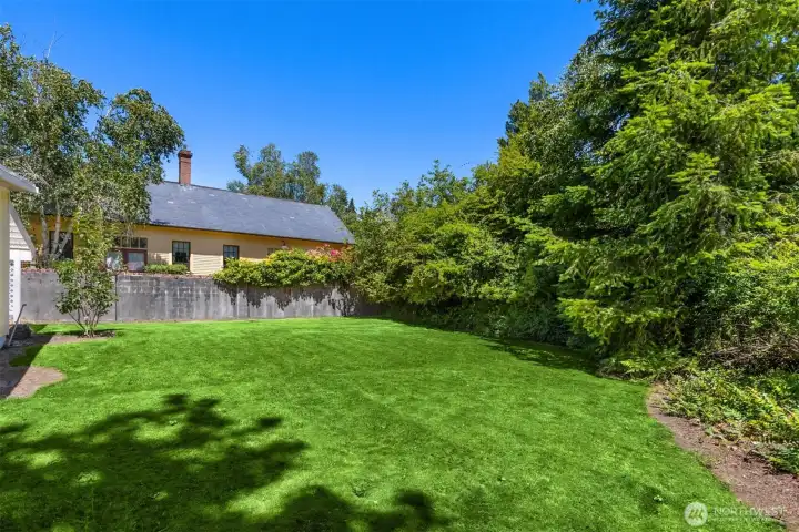 A deep vegetation buffer to the north provides enhanced privacy and a natural, wooded backdrop.