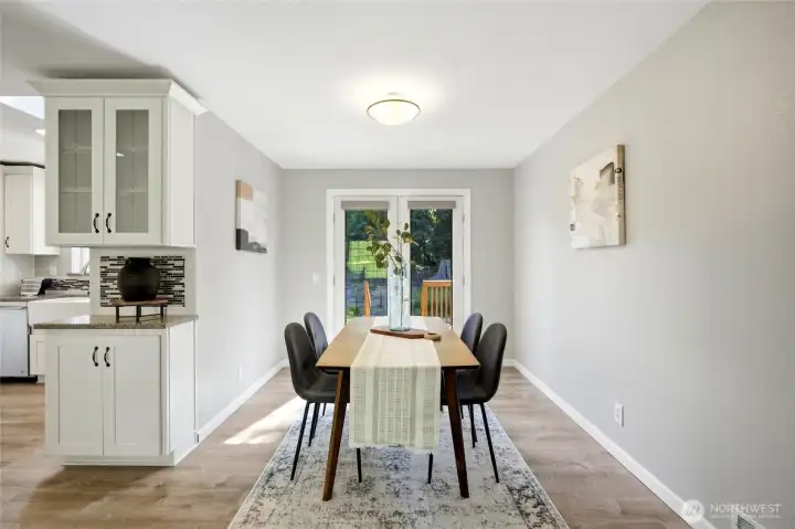 The formal dining room seamlessly connects the living room and kitchen, creating an ideal space for entertaining. French doors open to the expansive deck, where beautiful gardens provide a picturesque backdrop. The formal dining room seamlessly connects the living room and kitchen, creating an ideal space for entertaining. French doors open to the expansive deck, where beautiful gardens provide a picturesque backdrop.