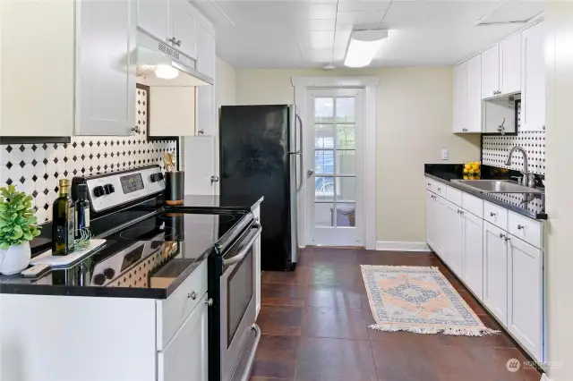 updated Kitchen with lots of cabinet space.  Beautiful vintage door leads to the expansive laundry room/mudroom.