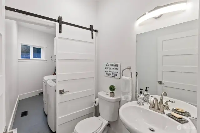 This room on the main floor doubles as a half bath for guests and your laundry area. The barn door allows you to close off the laundry space when company comes.