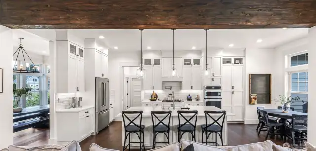 Kitchen with quartz counters, soft close cabinets and spacious island, breakfast nook and access to pantry, laundry and garage.