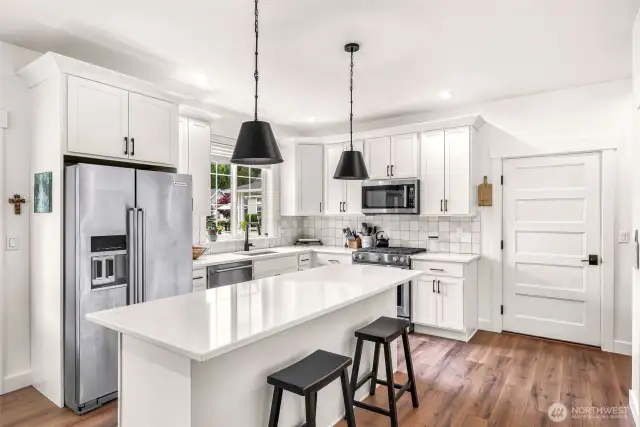Kitchen with quartz counters. stainless appliances and access to the garage. The adu features no threshold for ease of entry.