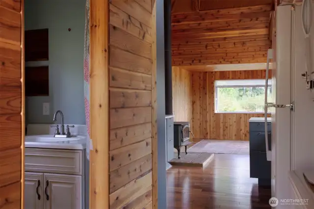Entry to tiny house- stairs and laundry on the left; shower, sink and urinal on right.