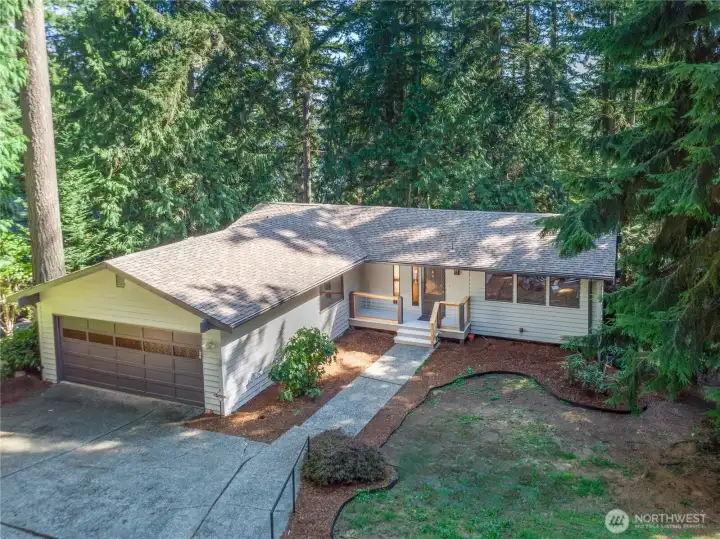 Beautiful NW quintessential setting, with towering, fragrant cedar and fir trees, and peek-a-boo views of the Bay. The exterior was painted in 2024, the yard is easy to maintain with native trees, rhododendrons, and beauty bark.
