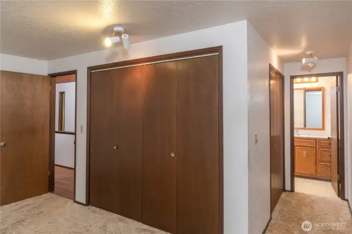 View of the primary bedroom, with a full bath on the right, and dual closets.