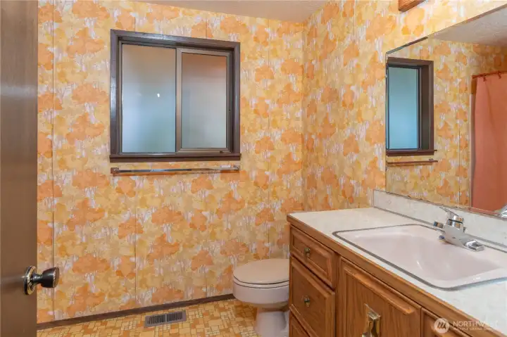 The lower level bathroom has a tub and shower to the left of the door.