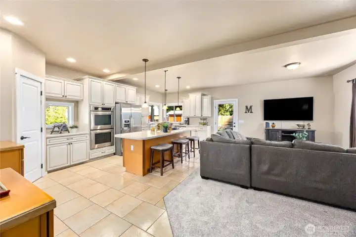 The open-concept kitchen and family room at the back of the home offers a spacious, connected living area that flows effortlessly to the covered patio.