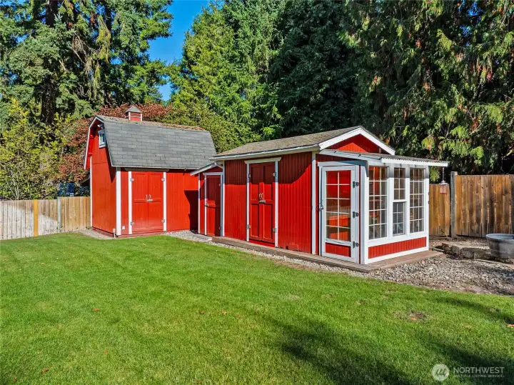 Farm-inspired storage sheds and an attached greenhouse add charm and functionality to the backyard.