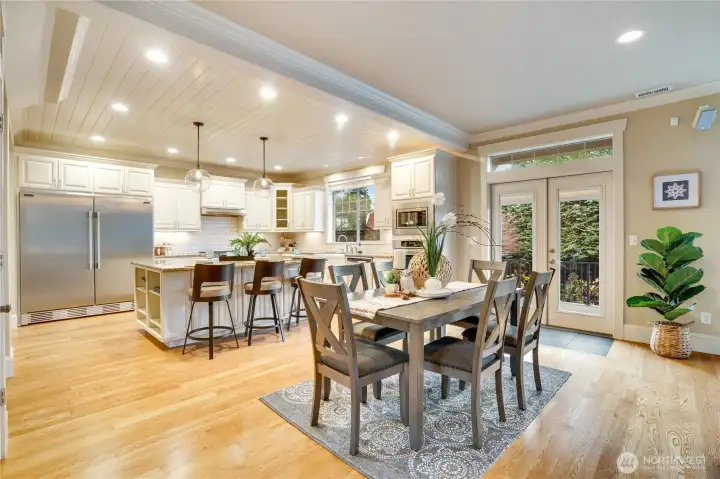 This entertainer’s dream offers plenty of room for guests to mingle, with a classic shiplap ceiling, stylish crown molding, and polished hardwood floors showcasing quality craftsmanship. French doors lead to a spacious back patio, creating an easy, inviting flow for carefree gatherings.