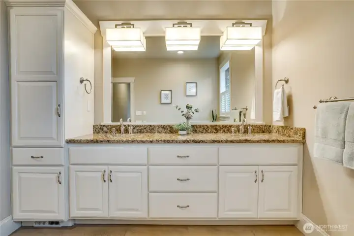 Double sinks, crown molding on the cabinets, and elevated trim around the mirror give it a hotel-like feel.