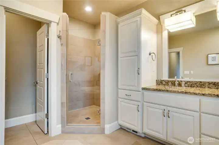 Indulge in a luxurious, spacious walk-in shower featuring elegant tile and dual showerheads.