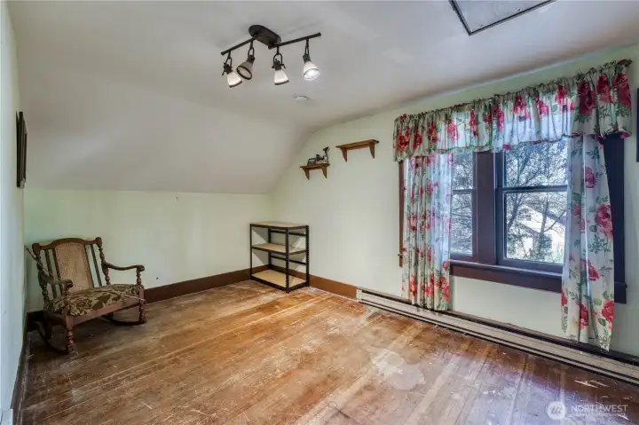 Large upstairs bedroom with fir floors is light and bright.
