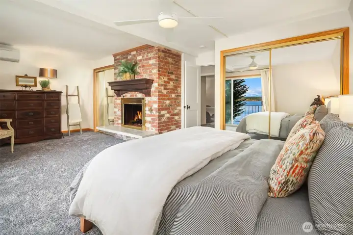 Primary bedroom with wood burning fireplace, new paint and carpeting and mini split for a warm, inviting environment.