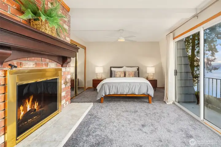 Primary bedroom with balcony and sliding doors opening to an expansive water view.
