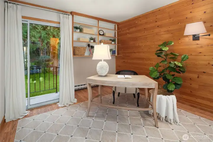 Second floor room makes a warm, welcoming office with wood accent wall, and balcony with forested views.