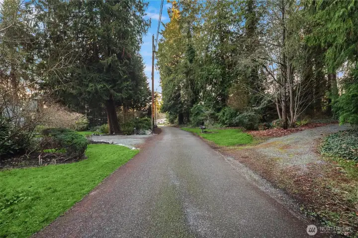 Entry road with driveway to home to the left, and gravel drive to the right to access this properties additional lot.