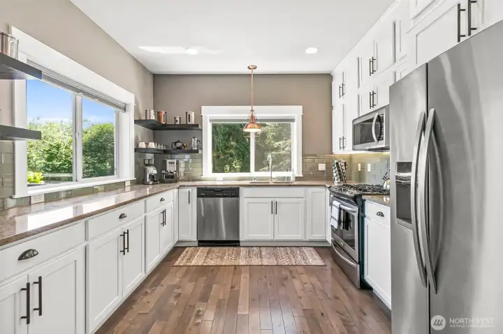 Spacious open kitchen with custom 9ft cabinetry offering abundant storage & ample conter space.