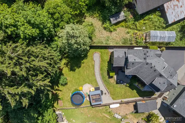 Aerial view showcasing the home's large lot, with the majority of the property located in the private backyard extending into the wooded area beyond.