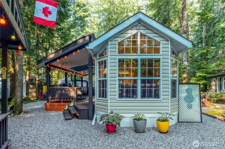 Front elevation featuring large windows & charming cottage-style entry.