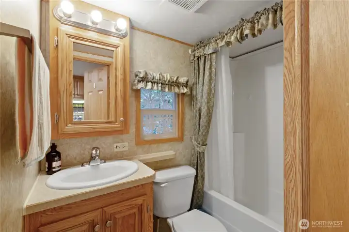 Full bathroom w/ vanity & storage.
