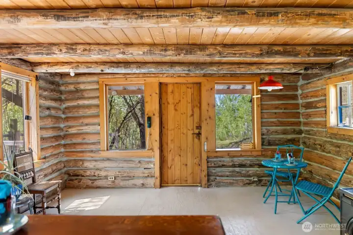 Cozy up on the main floor of this tiny home. Real log construction. Pine-wood ceiling. Painted wood floors.
