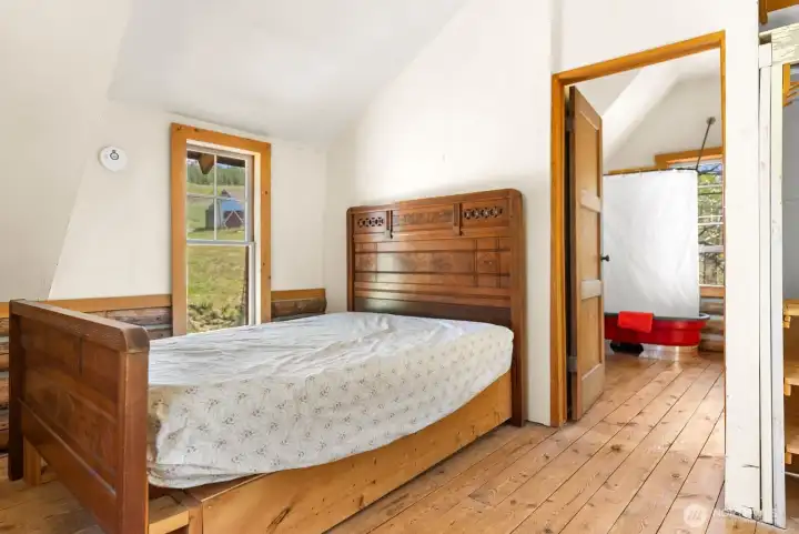 Loft primary Bedroom and ensuite Shower room. Distressed Wood floors have a rustic patina.