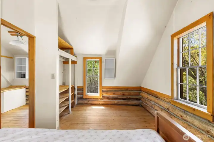 Open closet and shelving in primary Loft bedroom. Natural light with cool willow shading cabin through Summer.