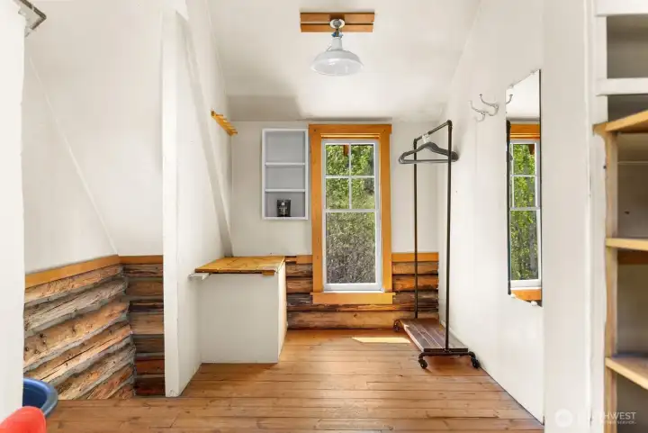 Shower room in Loft of cabin has wood floors and shelves and open closet for your personals and supplies.