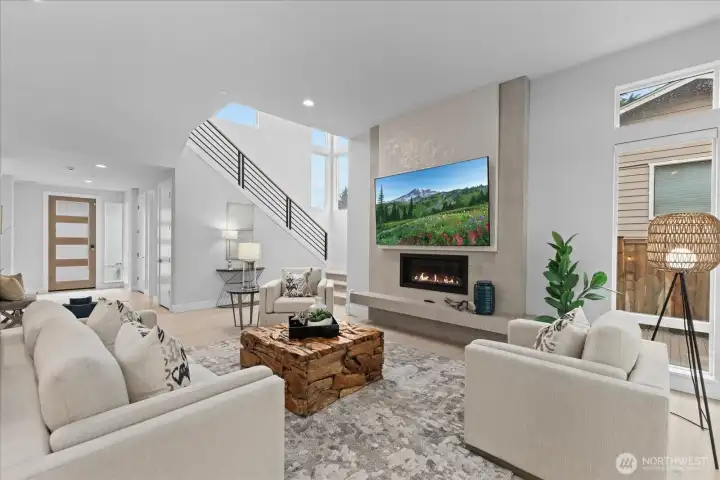 The great room makes a strong impression with a dramatic fireplace, soaring ceilings, expansive natural light, and open-concept flow designed for everyday living and entertaining in this Kirkland North Rose Hill luxury home.