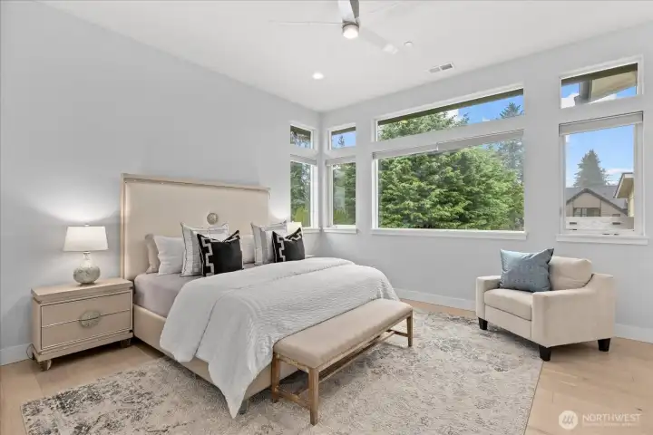 The light-filled primary suite feels like a private retreat with vaulted ceilings, expansive windows, beautiful natural light, and a calm, elevated feel in this Kirkland North Rose Hill luxury home.