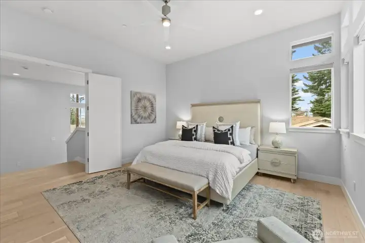 The spacious primary suite offers vaulted ceilings, expansive windows, abundant natural light, and quiet luxury, creating a true private retreat in this Kirkland North Rose Hill home.