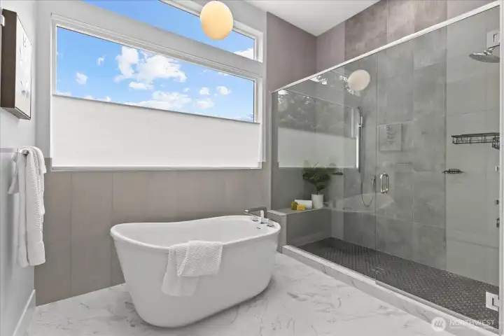 The spa-inspired primary bath features a sculptural soaking tub, oversized walk-in shower, serene finishes, and a luxurious design that creates a private retreat in this Kirkland North Rose Hill home.