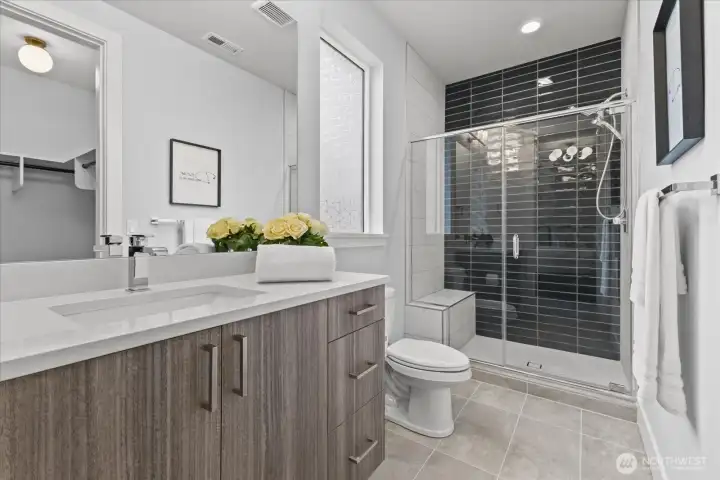 The downstairs suite bathroom features clean-lined modern design, high-end finishes, and everyday function, creating a fresh and inviting space in this Kirkland North Rose Hill luxury home.