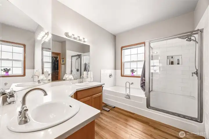 Primary Suite Bathroom features dual vanity, updated flooring tub & separate shower.
