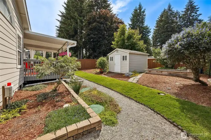Outbuilding provides added storage. Enjoy the gardening area.