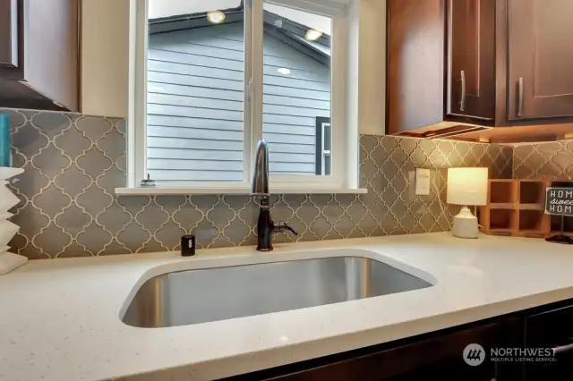 Kitchen w/Beautiful Custom Tile Backsplash, Gleaming Quartz Counters and Single Basin Stainless Steel Sink w/New Pull-Down Faucet