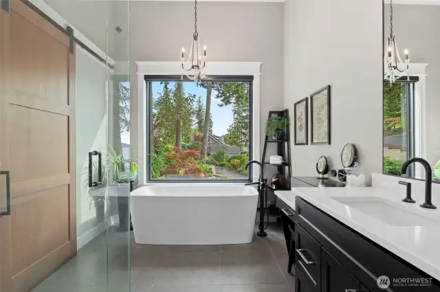 Accented with a chic chandelier and designed with sophistication, it features heated floors that offer warmth underfoot and under-cabinet lighting that casts a gentle, welcoming glow, providing a tranquil retreat for rejuvenation and relaxation. This space is not just a bathroom; it’s a personal spa experience that awaits, day or night.