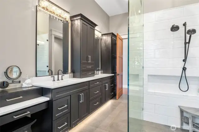 Designed with sophistication, this primary ensuite spa features heated floors that offer warmth underfoot and under-cabinet lighting that casts a gentle, welcoming glow and a large, zero barrier shower. Large walk-in California custom closet not shown.