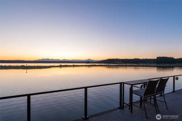 A serene waterfront view at sunset, with the stunning Olympic Mountains in the backdrop.