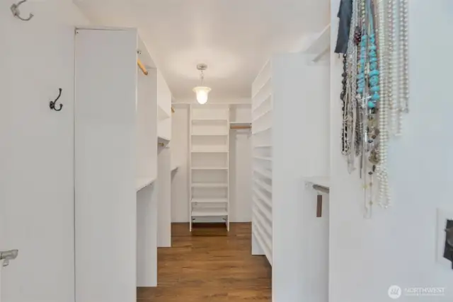Primary bedroom walk in closet features custom designed cabinetry to really make the best use of every inch of space!