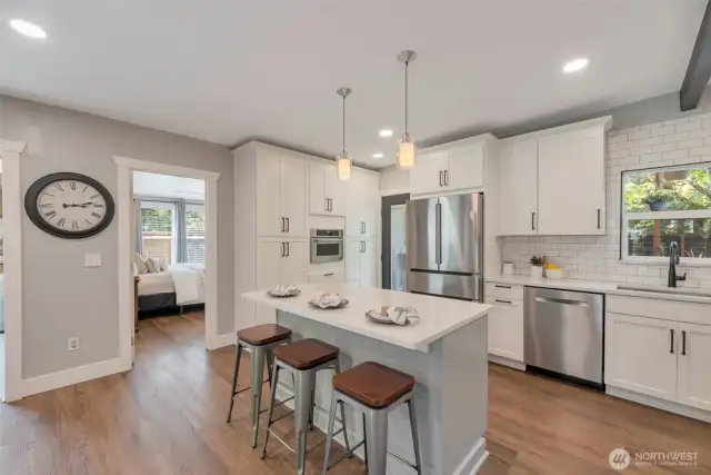 Recent kitchen remodel boasts high end cabinetry, tons of storage and pull-outs. Island with breakfast bar and pendants.