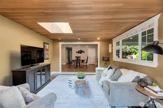 Living room features tons of natural light and gorgeous cedar tongue-and-groove ceiling.