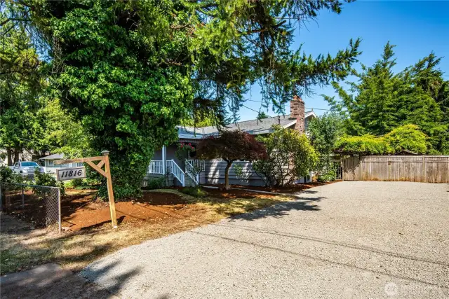 A level, generous driveway holds several cars. It has a new covering of gravel.