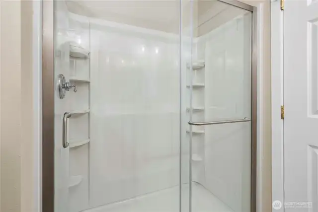 Spacious walk-in shower with built-in storage for convenience