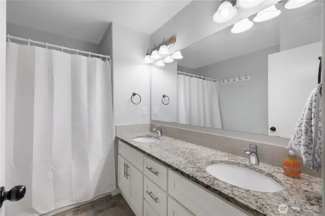 Primary bathroom w/ full tub and shower and double sinks.